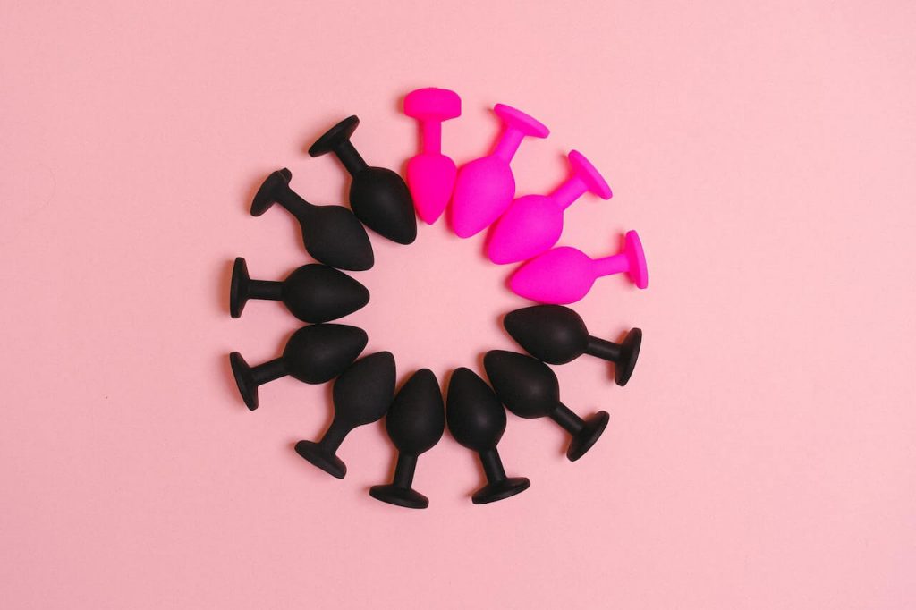 An image of a circle made out of butt plugs where more then half of them are black and the other half are pink